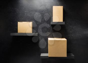cardboard box on wooden shelf at black background surface