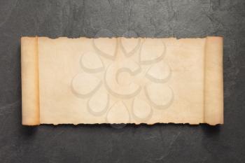 old retro aged paper parchment on slate stone background, top view