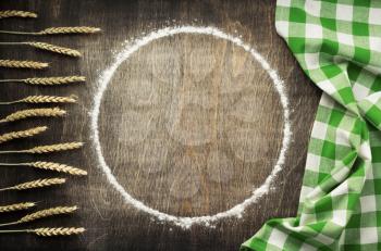 wheat flour and bakery ingredients on wooden background, top view