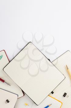 paper notebook and school supplies at white background