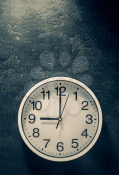wall clock at abstract black background texture