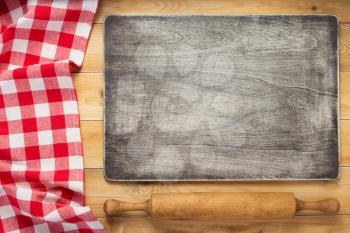 cloth napkin and cutting board at rustic wooden plank table background, top view
