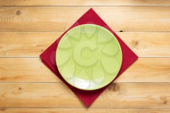 plate and napkin cloth at rustic wooden plank board table background, top view