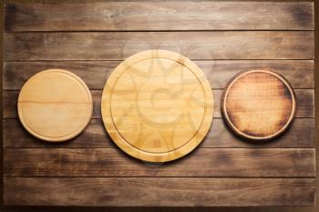 pizza cutting board at wooden plank table board background, top view