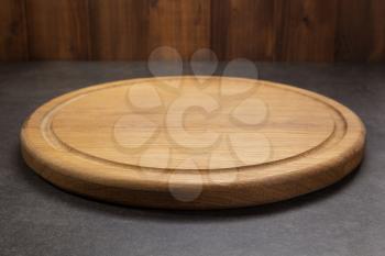 pizza cutting board at table in front, with wooden plank background