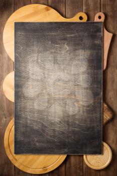 pizza cutting board at rustic wooden plank board background, top view