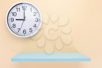 clock and shelf at wall background surface