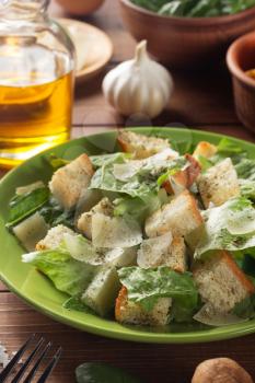 caesar salad and ingredients at wooden  background