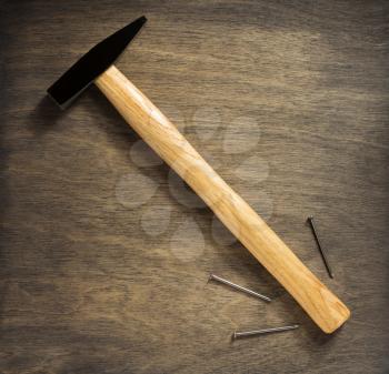 hammer tool and nail on wooden background