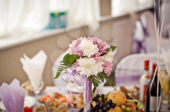 Bouquet on a wedding table. A beautiful multi-colored bouquet among a wedding table

