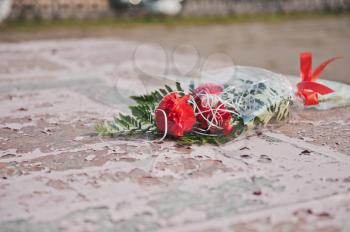 The flower lies on a monument.