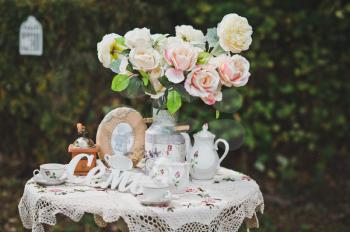 Little table with flowers and beautiful things in a garden.
