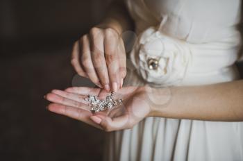 Earrings in hands of the young girl.