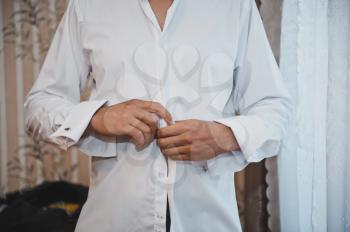 The young man dresses a white shirt.