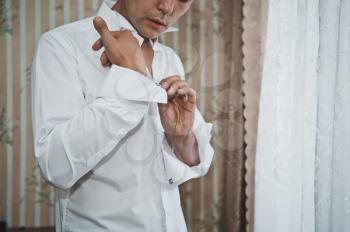 The young man dresses a white shirt.