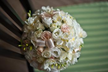 Bouquet from beige flowers on a wooden chair.