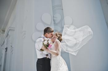 Kiss men and women on the background of the white Church.