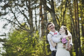 The tender embrace of the newlyweds in the woods.