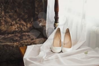 White wedding shoes on a table.