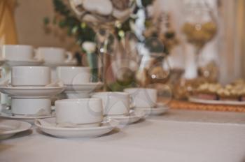 The table with tea cups and sweets.