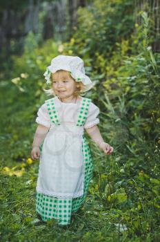 Girl in a dress in green peas in the garden.