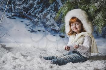 Portrait of a child under the winter tree.