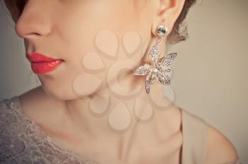 Advertizing of female ornaments, part of a girl's face with an earring.
