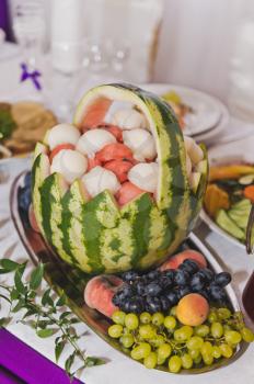 A basket carved from a watermelon on the table.