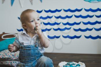 A child tries out the cake with your hands.