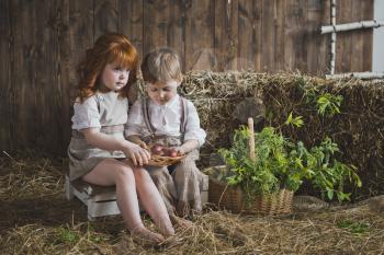 A girl and a boy holding a dish with Easter eggs.