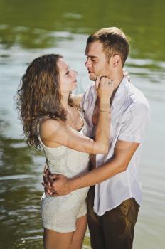 Young guy and girl hugging on nature background.