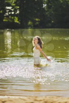Portrait of a girl standing in the water in the pond.