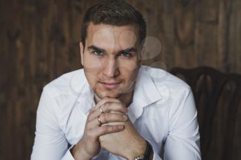 Portrait of a young man sitting on a chair.