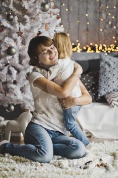 Mother hugs little daughter in the new years eve.
