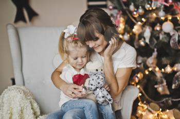 Mother and daughter in the white chair in front of a huge clock.