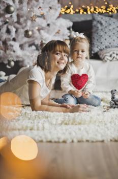 Child and parent play with toys on the floor.