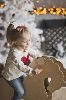 Little girl plays on the background of Christmas decorations.