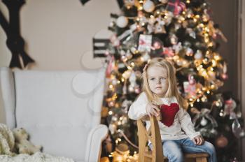 Portrait of a child on a background of Christmas tree decorated with balls.
