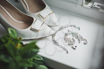 Crystal earrings and white shoes.