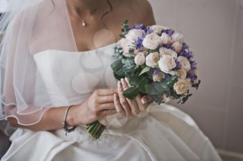 A bouquet of flowers in hands of the bride.