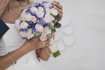 A bouquet of flowers in hands of bride at the wedding.