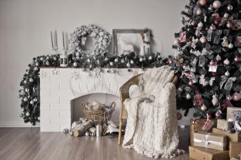 Christmas cozy place with a burning Christmas tree and white chair.