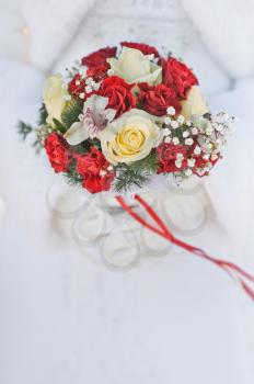 Red roses in a bouquet for a winter wedding.