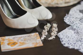 Shoes earrings and additional accessories of the bride before the wedding.