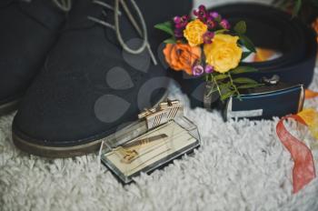 Bright multicolored bouquet and mens accessories on white background.