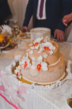 Wedding cake of two tiers decorated with flowers.