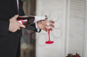 The process of filling the glass of wine.