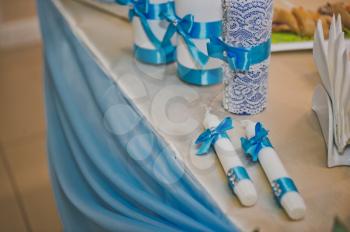 Two candles decorated with blue ribbons.