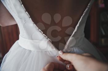 The process of dressing the wedding dress to the bride.