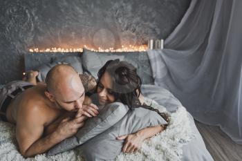 A man and a girl bask in the morning in bed.